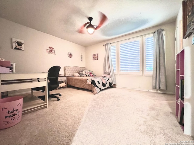 bedroom featuring carpet flooring, a desk, ceiling fan, and a textured ceiling