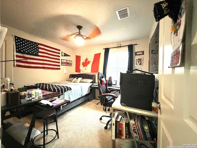 bedroom with carpet, a desk, a textured ceiling, and a ceiling fan