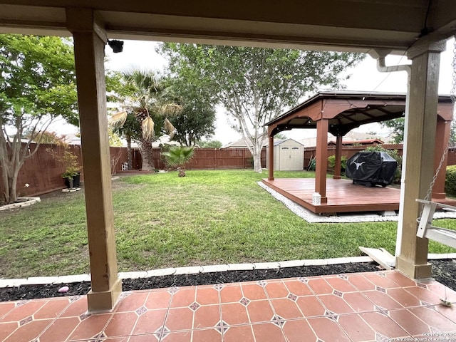 view of yard featuring a gazebo, a storage unit, a deck, an outdoor structure, and a patio area