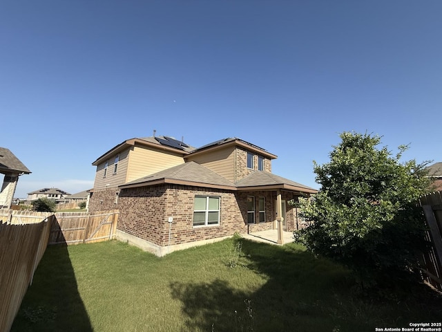 15319 Comanche, San Antonio, TX 78233 - back of house featuring solar panels, brick siding, and a patio area