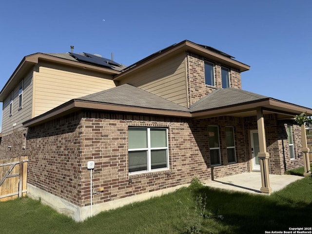 15319 Comanche, San Antonio, TX 78233 - view of side of home featuring brick siding, roof mounted solar panels, and a patio