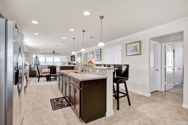 13227 Cache Crk, San Antonio, TX 78253 - kitchen featuring stainless steel fridge, a sink, a kitchen bar, dark brown cabinetry, and open floor plan