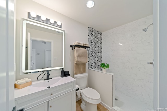 1108 S Gevers St, San Antonio, TX 78203 - bathroom with a tile shower, toilet, vanity, and wood finished floors