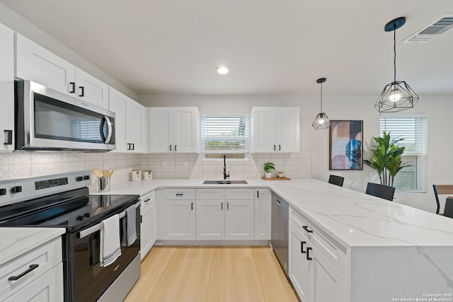 1108 S Gevers St, San Antonio, TX 78203 - kitchen featuring appliances with stainless steel finishes, a sink, a peninsula, white cabinetry, and recessed lighting