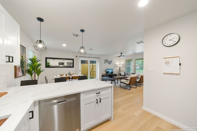 1108 S Gevers St, San Antonio, TX 78203 - kitchen with stainless steel dishwasher, a peninsula, light wood-style flooring, white cabinetry, and pendant lighting