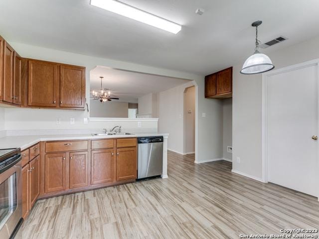 1818 Vinca Mnr, San Antonio, TX 78260 - kitchen featuring stainless steel appliances, a sink, brown cabinetry, light wood-type flooring, and light countertops