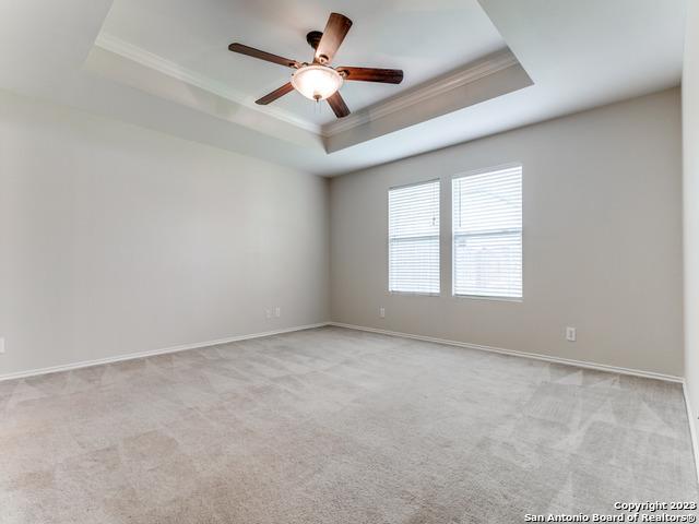 1818 Vinca Mnr, San Antonio, TX 78260 - spare room featuring a tray ceiling, crown molding, carpet floors, a ceiling fan, and baseboards