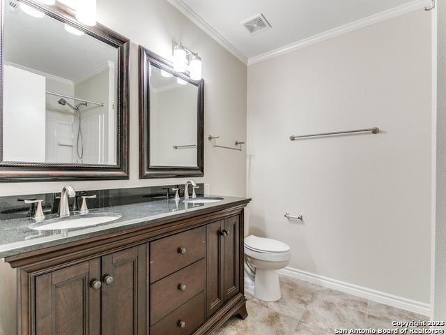1818 Vinca Mnr, San Antonio, TX 78260 - full bathroom featuring crown molding, toilet, double vanity, and baseboards
