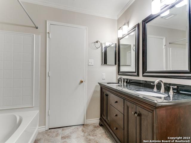 1818 Vinca Mnr, San Antonio, TX 78260 - bathroom featuring double vanity, crown molding, baseboards, and tile patterned floors