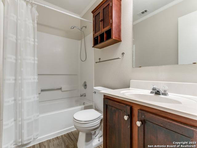 1818 Vinca Mnr, San Antonio, TX 78260 - bathroom featuring ornamental molding, toilet, shower / bath combo, wood finished floors, and vanity
