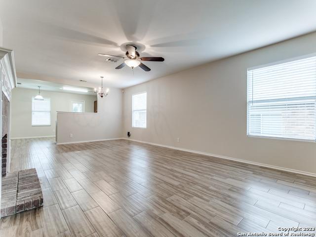 1818 Vinca Mnr, San Antonio, TX 78260 - unfurnished living room featuring a ceiling fan, wood finished floors, and baseboards