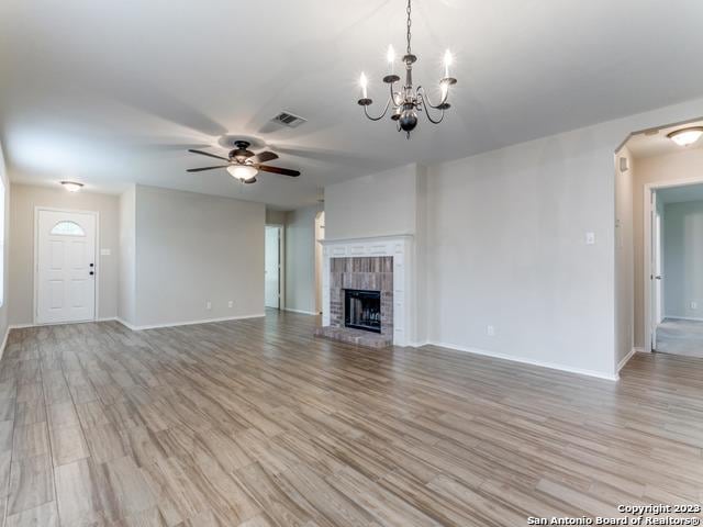 1818 Vinca Mnr, San Antonio, TX 78260 - unfurnished living room featuring ceiling fan, light wood finished floors, baseboards, a fireplace, and a chandelier