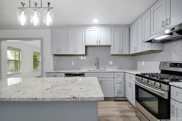 5515 Rolling Rdg, San Antonio, TX 78228 - kitchen featuring appliances with stainless steel finishes, under cabinet range hood, a sink, light wood-style flooring, and light stone countertops