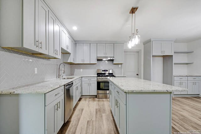 5515 Rolling Rdg, San Antonio, TX 78228 - kitchen featuring appliances with stainless steel finishes, a sink, light wood-type flooring, and a center island