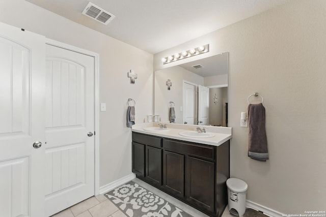 7303 Altair Loop, San Antonio, TX 78252 - full bath with tile patterned flooring, double vanity, and baseboards