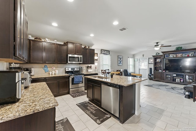 7303 Altair Loop, San Antonio, TX 78252 - kitchen featuring appliances with stainless steel finishes, a sink, ceiling fan, dark brown cabinets, and open floor plan