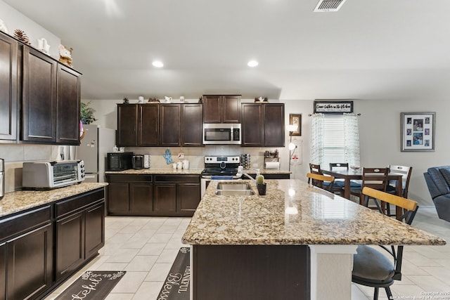 7303 Altair Loop, San Antonio, TX 78252 - kitchen featuring appliances with stainless steel finishes, a breakfast bar, tasteful backsplash, a sink, and recessed lighting
