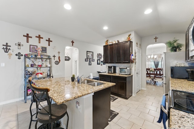 7303 Altair Loop, San Antonio, TX 78252 - kitchen featuring arched walkways, a sink, light tile patterned floors, a center island with sink, and lofted ceiling