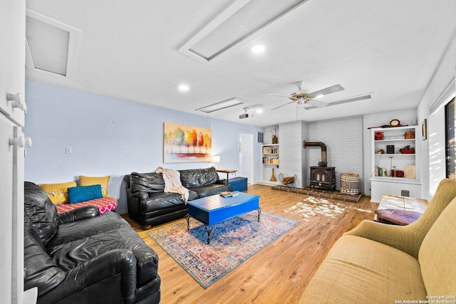 135 Fallow Dr, Kerrville, TX 78028 - living area with attic access, a wood stove, ceiling fan, and hardwood / wood-style flooring