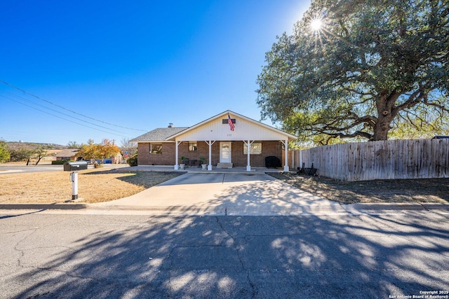 135 Fallow Dr, Kerrville, TX 78028 - view of front of house featuring fence, brick siding, and covered porch