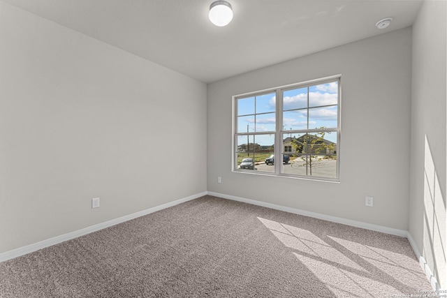 carpeted empty room with baseboards