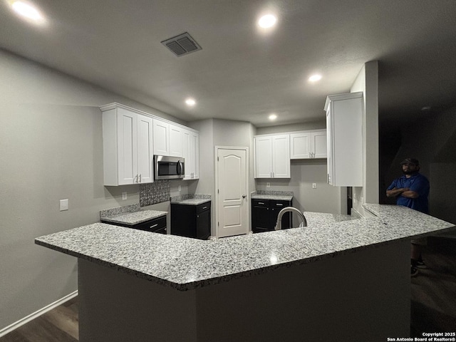 12131 Lantana Cv, San Antonio, TX 78253 - kitchen featuring stainless steel microwave, baseboards, a peninsula, dark wood finished floors, and recessed lighting