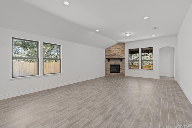 2171 Oak Run Pkwy, New Braunfels, TX 78132 - unfurnished living room featuring healthy amount of natural light, recessed lighting, light wood-style flooring, arched walkways, and a fireplace