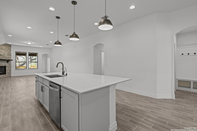 2171 Oak Run Pkwy, New Braunfels, TX 78132 - kitchen with a sink, arched walkways, open floor plan, stainless steel dishwasher, and light wood-style flooring