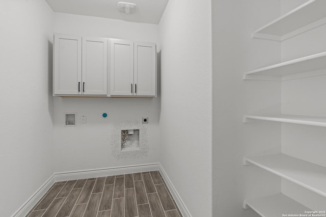 2171 Oak Run Pkwy, New Braunfels, TX 78132 - washroom with hookup for an electric dryer, baseboards, dark wood-type flooring, and cabinet space