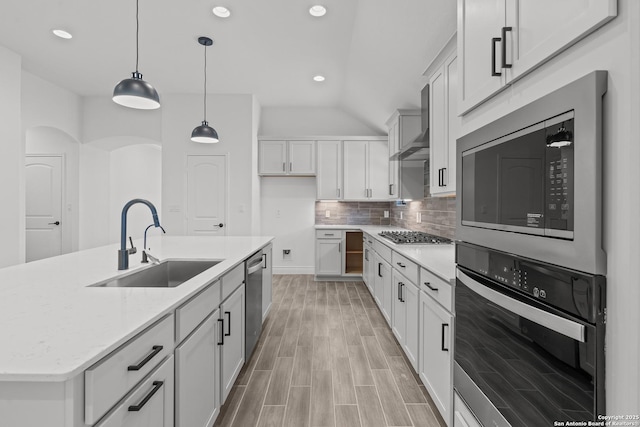 2171 Oak Run Pkwy, New Braunfels, TX 78132 - kitchen with appliances with stainless steel finishes, a sink, wall chimney exhaust hood, tasteful backsplash, and light wood-style flooring