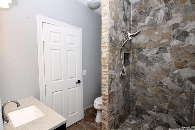 23127 Opportunity, Elmendorf, TX 78112 - bathroom featuring a tile shower, vanity, toilet, and marble finish flooring