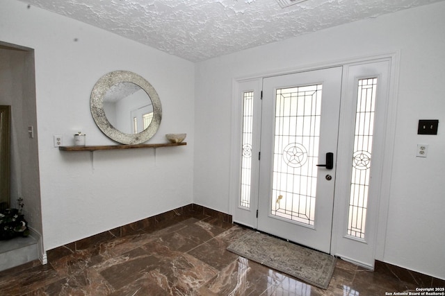 23127 Opportunity, Elmendorf, TX 78112 - entryway with a textured ceiling, baseboards, and dark marble finish flooring