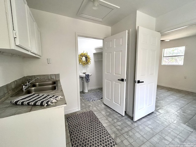 23127 Opportunity, Elmendorf, TX 78112 - kitchen with a sink, white cabinetry, and baseboards