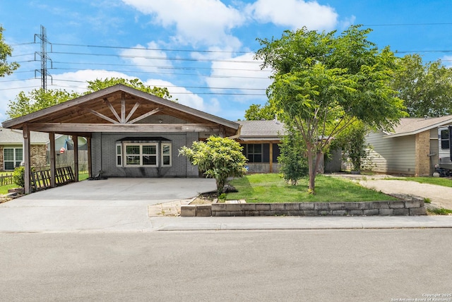 single story home featuring driveway, a front lawn, and brick siding