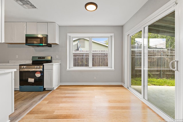 kitchen with appliances with stainless steel finishes, light wood-style flooring, white cabinets, light countertops, and baseboards