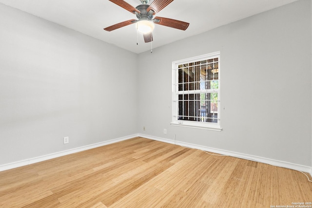spare room featuring baseboards, wood finished floors, and ceiling fan
