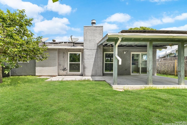 back of property featuring brick siding, a chimney, and a patio