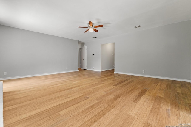 unfurnished room with ceiling fan, light wood-style flooring, and baseboards
