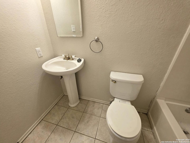 3123 Opal, San Antonio, TX 78245 - bathroom with tile patterned flooring, toilet, a tub, a textured wall, and baseboards