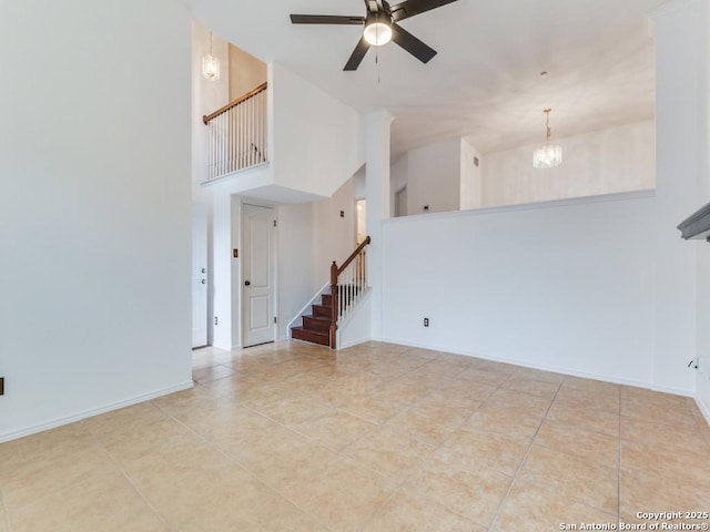 23 Terrace, San Antonio, TX 78230 - unfurnished living room with stairway, ceiling fan, tile patterned flooring, a chandelier, and a towering ceiling