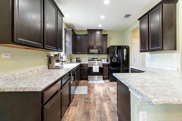 4351 E Safe Hbr, San Antonio, TX 78244 - kitchen featuring black appliances, a sink, dark brown cabinetry, light wood-type flooring, and light countertops