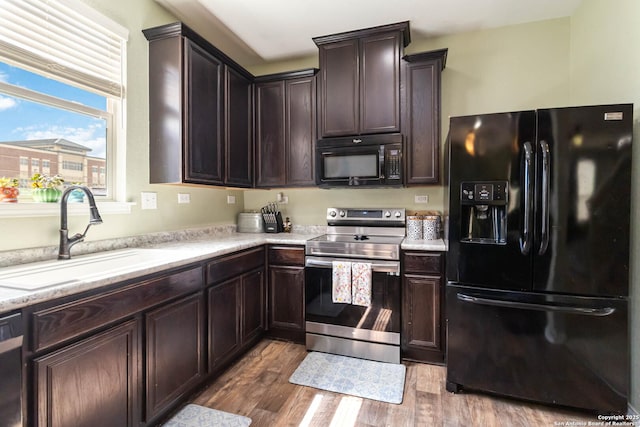 4351 E Safe Hbr, San Antonio, TX 78244 - kitchen featuring black appliances, a sink, wood finished floors, dark brown cabinets, and light countertops
