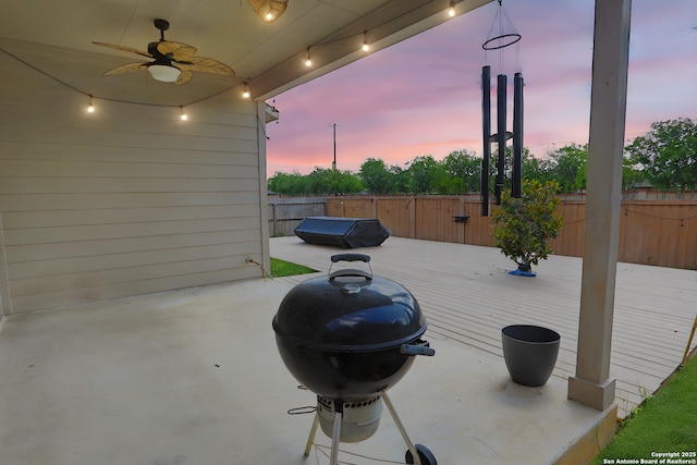 8228 Llano Parke, San Antonio, TX 78254 - patio terrace at dusk with a ceiling fan, a fenced backyard, a wooden deck, and a grill