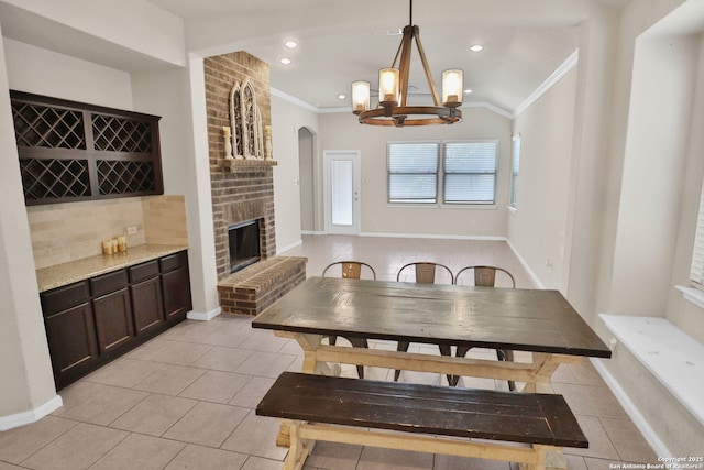 8228 Llano Parke, San Antonio, TX 78254 - dining area featuring light tile patterned floors, ornamental molding, a chandelier, a fireplace, and baseboards
