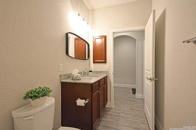 565 Rosemellow, New Braunfels, TX 78132 - half bathroom with toilet, vanity, wood finished floors, a textured wall, and baseboards