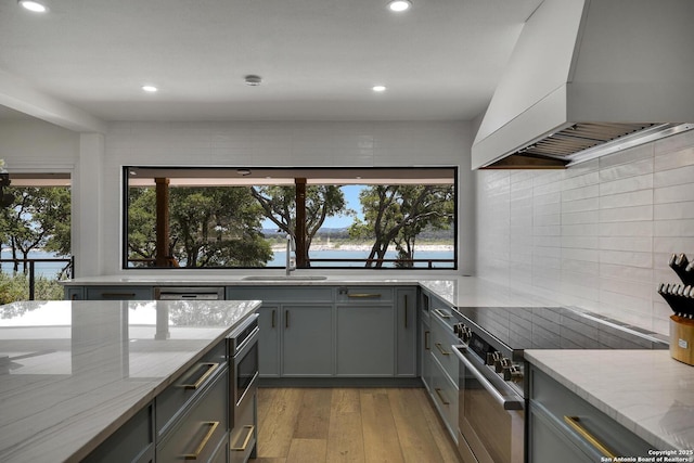 772 Lakebreeze, Canyon Lake, TX 78133 - kitchen featuring premium range hood, stainless steel range with electric cooktop, gray cabinets, a sink, and light stone counters