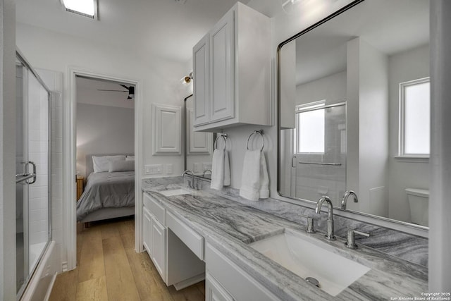 772 Lakebreeze, Canyon Lake, TX 78133 - ensuite bathroom with a shower with shower door, double vanity, and wood finished floors