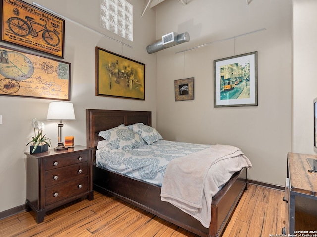 1339 S Flores St Unit 103, San Antonio, TX 78204 - bedroom featuring light wood finished floors, baseboards, and a high ceiling
