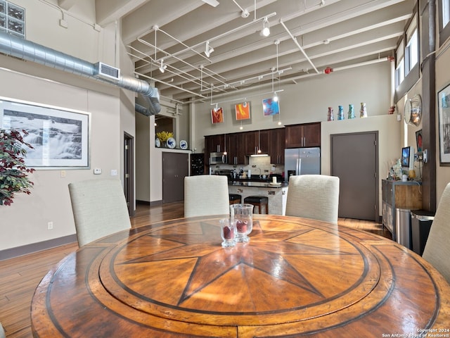 1339 S Flores St Unit 103, San Antonio, TX 78204 - dining area with a towering ceiling, light wood-style floors, and baseboards