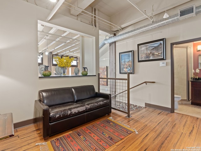 1339 S Flores St Unit 103, San Antonio, TX 78204 - living area with wood finished floors, baseboards, and an upstairs landing